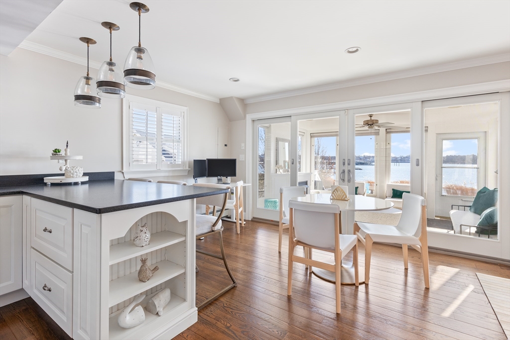 25 Bay Street Hull, MA 02045 - Photo 2 of 27 a kitchen with a table chairs stove and wooden floor