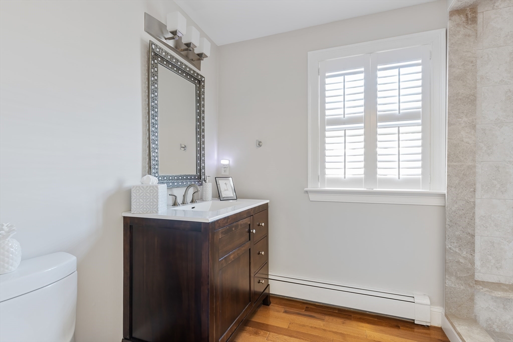 25 Bay Street Hull, MA 02045 - Photo 22 of 27 a bathroom with a sink a toilet and a mirror