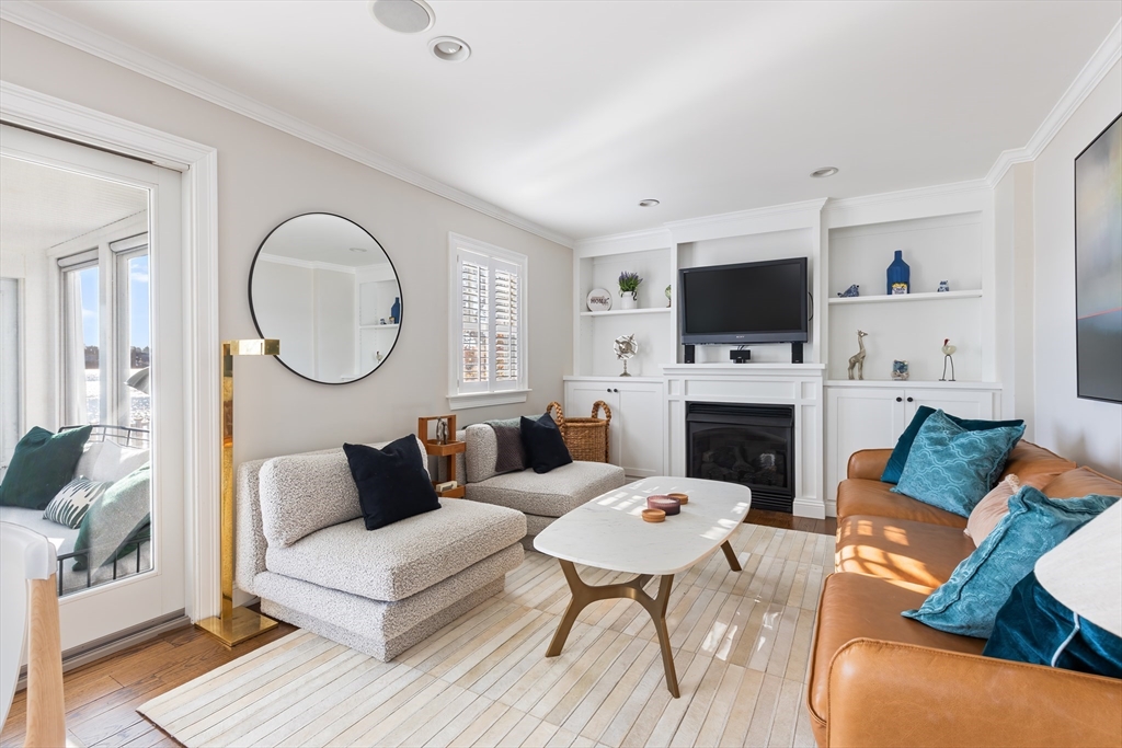 25 Bay Street Hull, MA 02045 - Photo 5 of 27 a living room with furniture a fireplace a flat screen tv and a fireplace