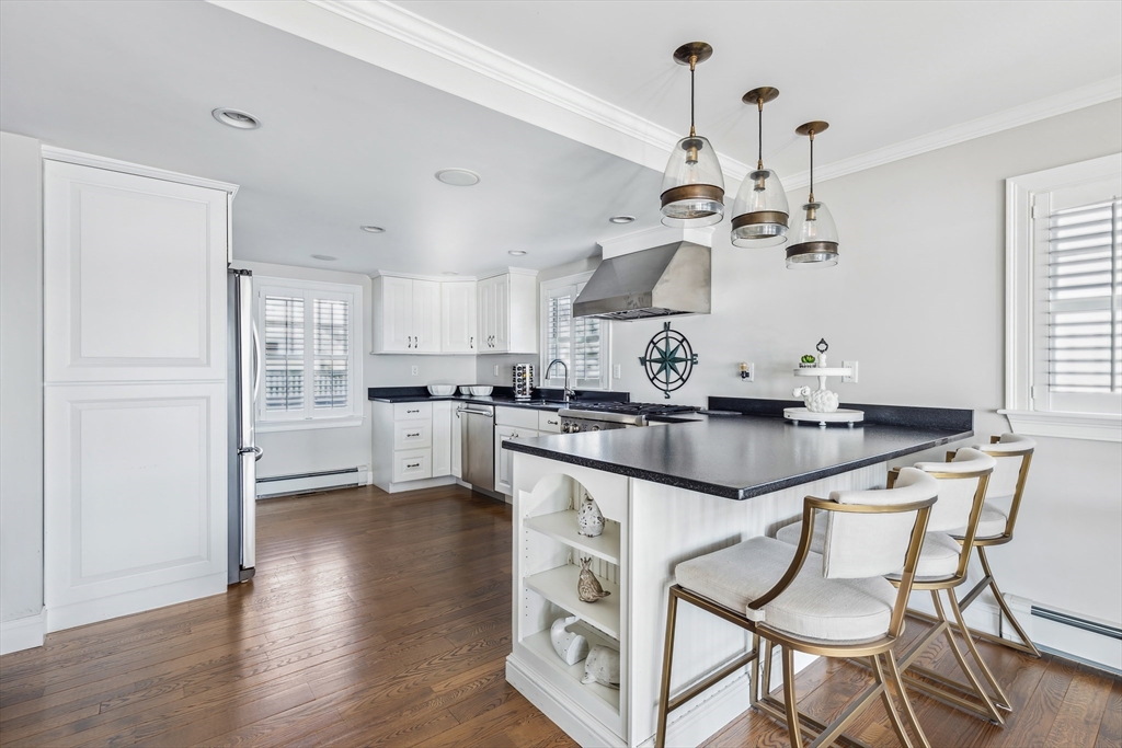 25 Bay Street Hull, MA 02045 - Photo 7 of 27 a kitchen with stainless steel appliances granite countertop a sink a stove and chairs