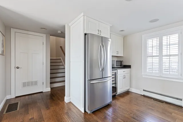 a kitchen with stainless steel appliances a refrigerator and wooden floor