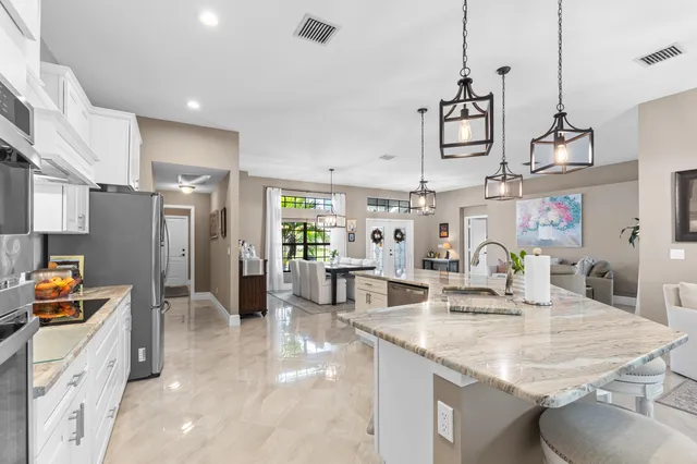 a kitchen with stainless steel appliances kitchen island granite countertop a sink and cabinets