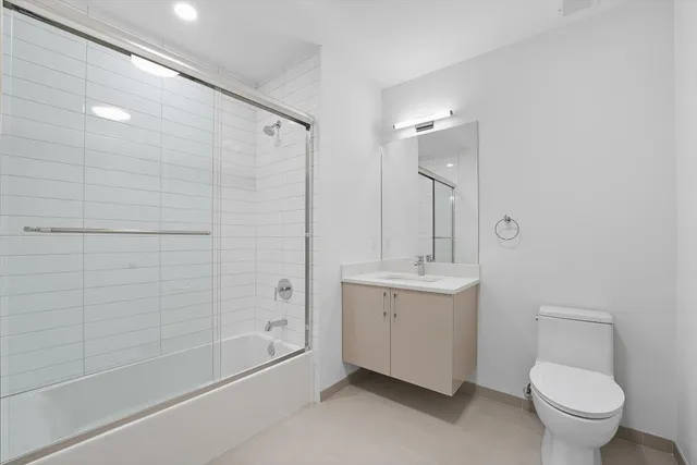 a bathroom with a bathtub shower sink mirror and toilet
