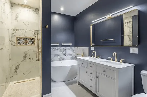 a bathroom with a double vanity sink mirror and bathtub