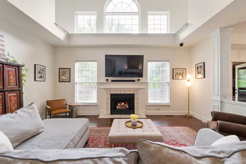 a kitchen with stainless steel appliances granite countertop a refrigerator a sink dishwasher a stove a dining table and chairs with wooden floor