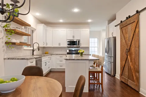 a bedroom with a bed a mirror on dresser and a wooden floor