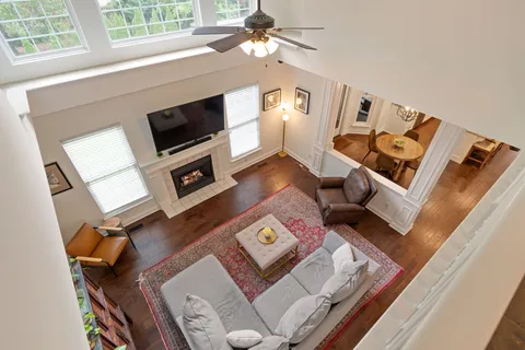 an aerial view of a swimming pool with a yard and large trees