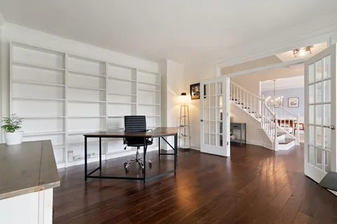 a living room with dining table and paintings on the wall