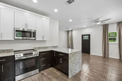 a kitchen with stainless steel appliances granite countertop a stove a sink and a microwave
