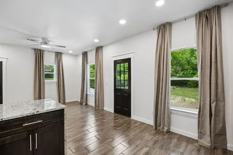 a view of hallway with a large window and wooden floor