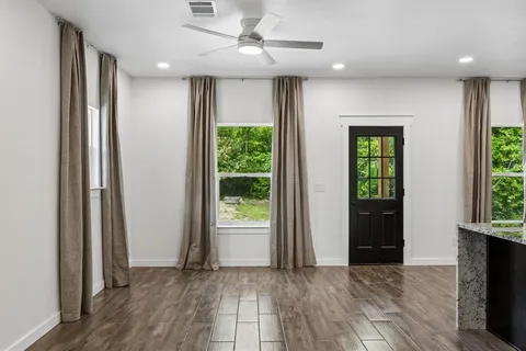 an empty room with wooden floor and windows