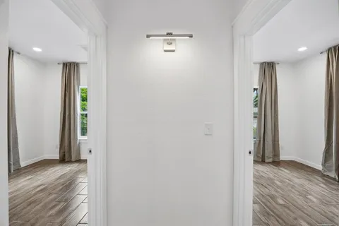a view of a hallway with wooden floor and closet area