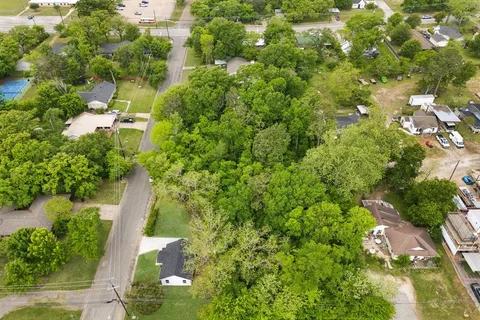 an aerial view of residential houses with outdoor space and trees