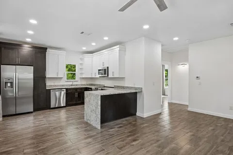 a large kitchen with stainless steel appliances granite countertop a stove a refrigerator a sink a microwave and island