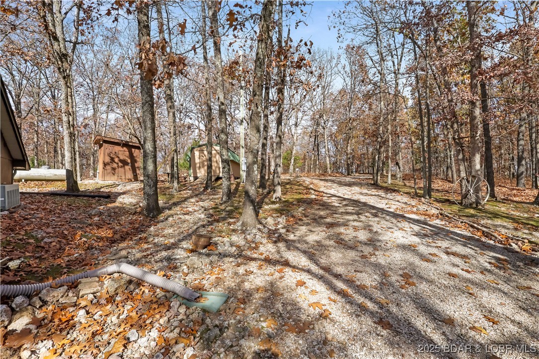 16376 Twisted Tree Road Barnett, MO 65011 - Photo 35 of 48 Well house & shed, with gentle driveway to gated e
