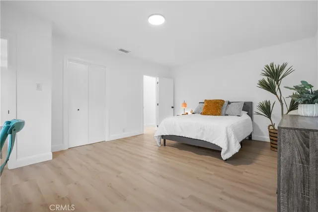 a bedroom with a bed and wooden floor