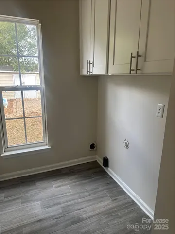 an empty room with wooden floor and cabinets
