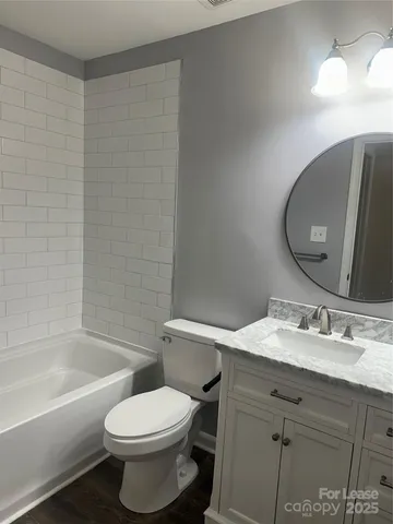 a bathroom with a granite countertop toilet a sink and bathtub