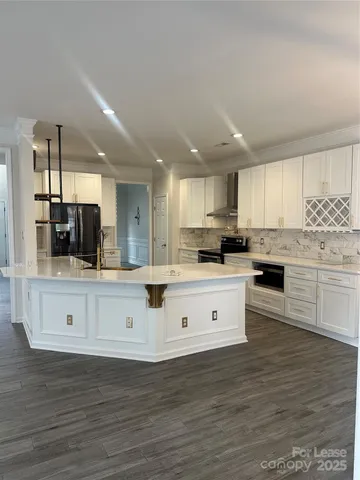 a large white kitchen with cabinets
