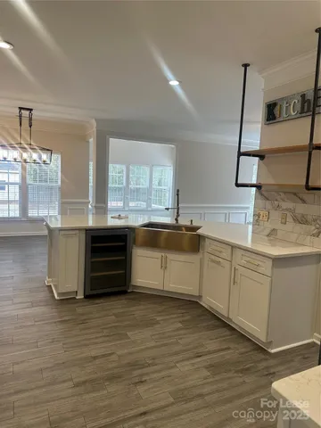 a kitchen with granite countertop a sink cabinets and wooden floor