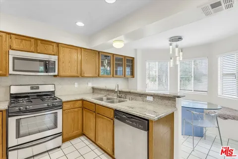 a kitchen that has a sink and a stove in it