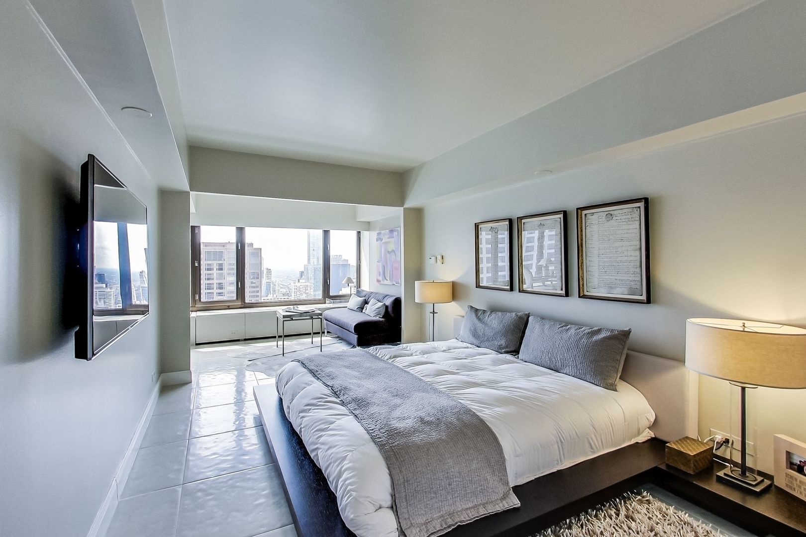 175 East Delaware Place, Unit 5819 Chicago, IL 60611 - Photo 13 of 22 a spacious bedroom with a large bed and a large window