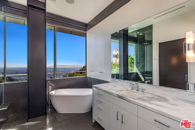 a bathroom with a granite countertop sink and a bathtub