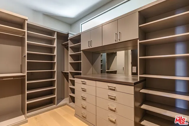a view of walk in closet with empty racks