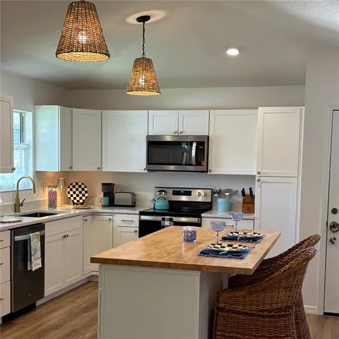 a kitchen with stainless steel appliances a sink a stove a microwave and cabinets