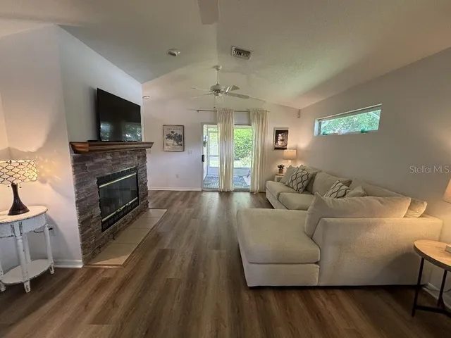 a living room with furniture a flat screen tv and a fireplace