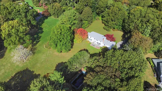 an aerial view of residential house with outdoor space and trees all around