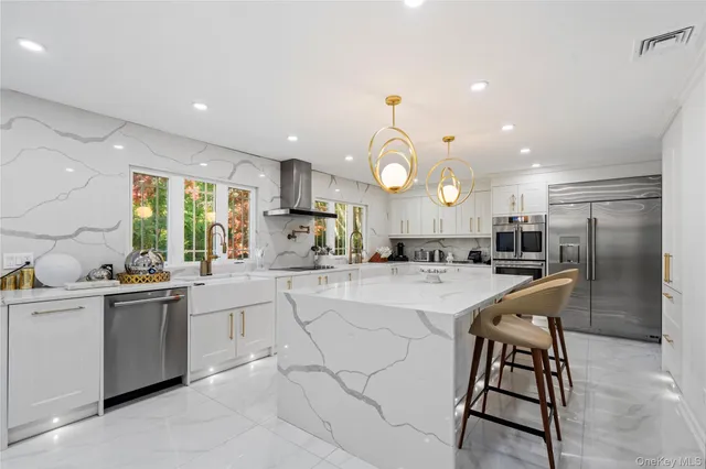 a large white kitchen with a large window and stainless steel appliances