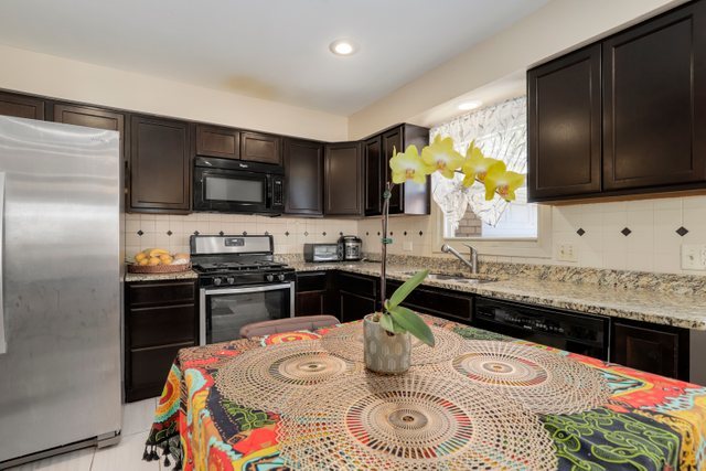 8369 West Kay Street Niles, IL 60714 - Photo 11 of 26 a kitchen with stainless steel appliances granite countertop a sink and a stove