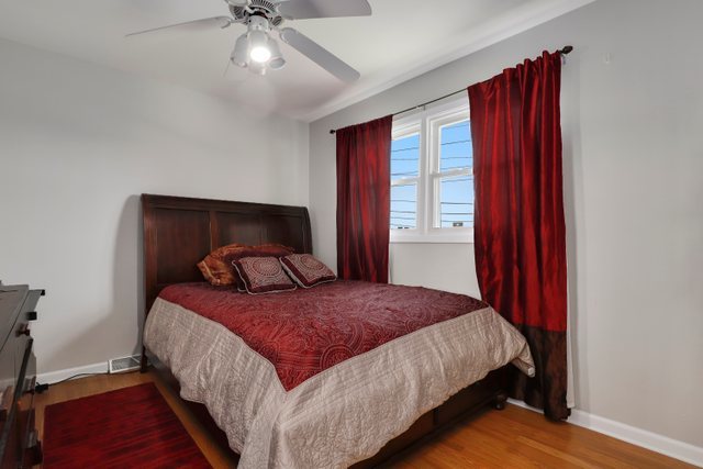 8369 West Kay Street Niles, IL 60714 - Photo 13 of 26 a bedroom with a large bed and a chandelier