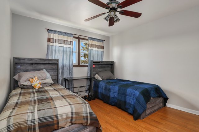 8369 West Kay Street Niles, IL 60714 - Photo 14 of 26 a bedroom with a bed and wooden floor