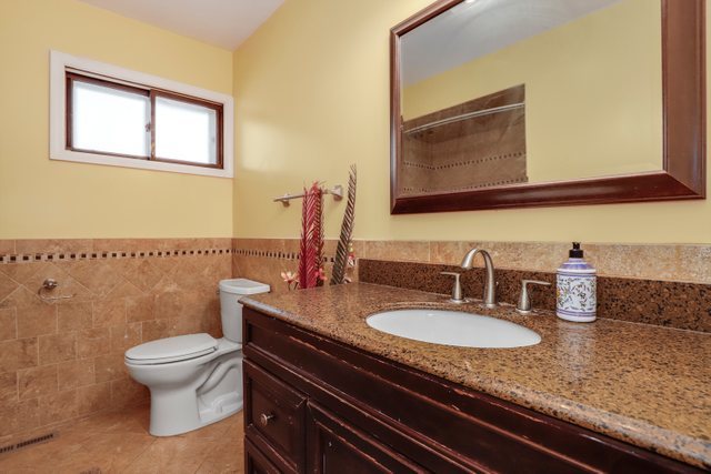 8369 West Kay Street Niles, IL 60714 - Photo 15 of 26 a bathroom with a granite countertop toilet sink and mirror
