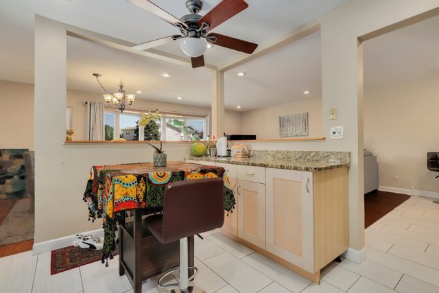 8369 West Kay Street Niles, IL 60714 - Photo 9 of 26 a open kitchen with stainless steel appliances granite countertop a stove a sink a dining table and chairs with wooden floor