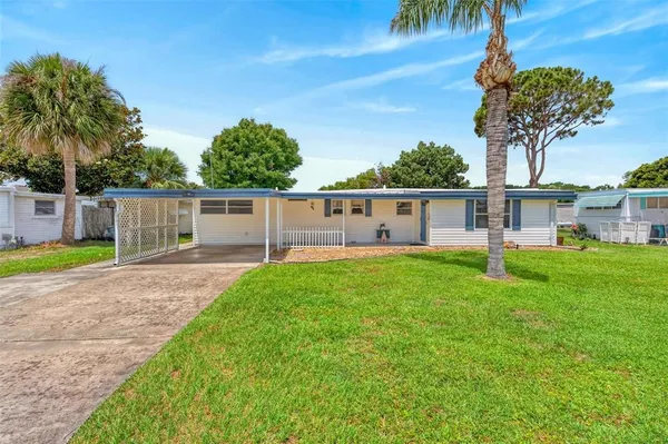 a view of a house with backyard and a tree