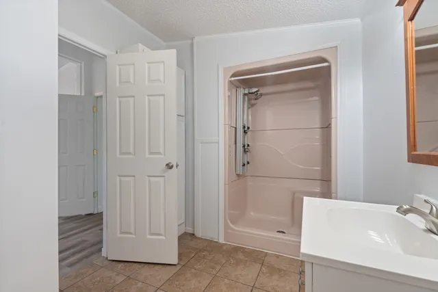a bathroom with a tub shower and vanity