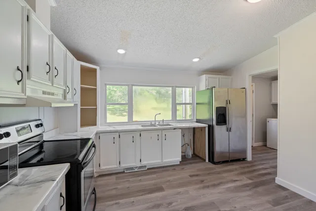 a kitchen with stainless steel appliances granite countertop a stove and a refrigerator