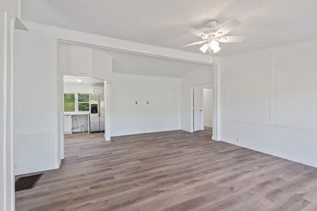 a view of an empty room with wooden floor