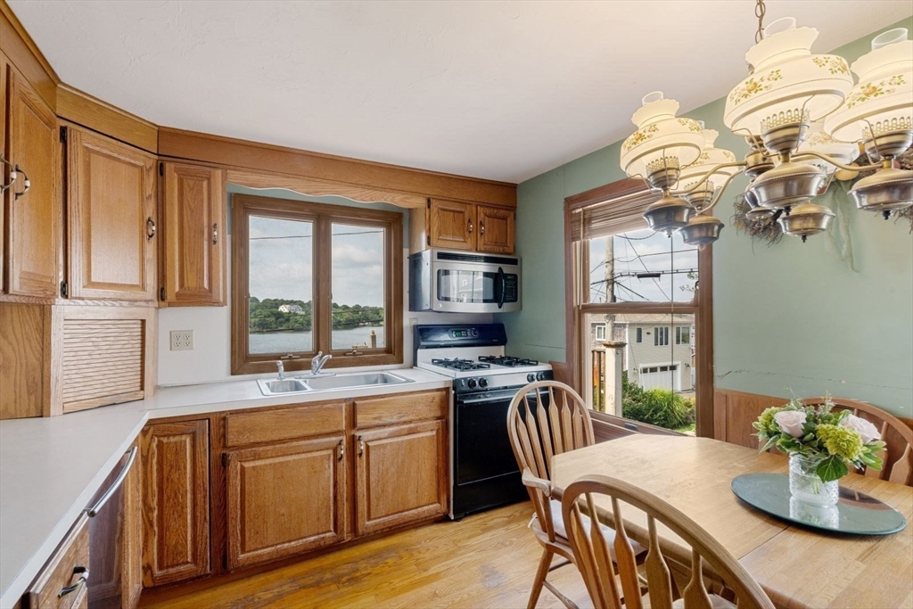 49 Summit Avenue Hull, MA 02045 - Photo 18 of 29 a kitchen with a table chairs stove and cabinets