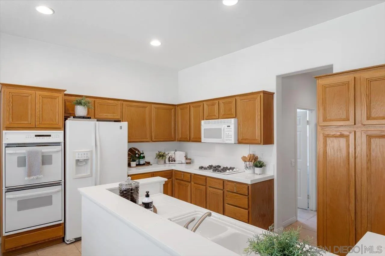 2195 Stone Castle Fallbrook, CA 92028 - Photo 8 of 37 a kitchen with a refrigerator sink and cabinets