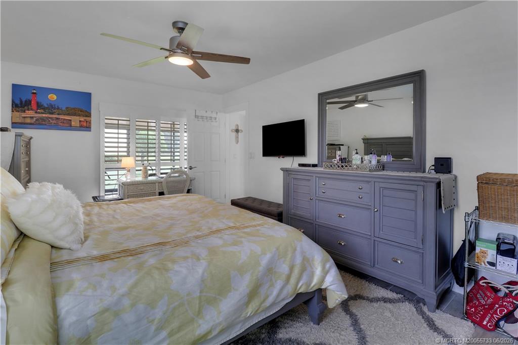 1001 Keystone Drive, Unit A Jupiter, FL 33458 - Photo 19 of 30 a bedroom with a bed and a flat screen tv