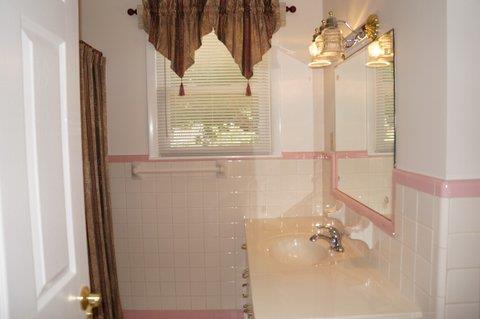 2117 Layton Road Clarksville, TN 37043 - Photo 15 of 20 Second full bath in the upstairs hallway has tile with just a small amount of pink tile as a border. It's not overdone at all with pink tile. Bath tub and shower combination.
