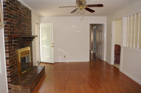 2117 Layton Road Clarksville, TN 37043 - Photo 7 of 20 Den with laminate flooring and a natural gas log fireplace that features a brick hearth and surround.