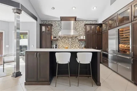 a dining room with wooden floor a chandelier a glass table and chairs