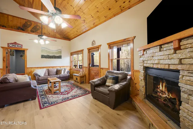 a living room with lots of furniture kitchen view and a large window