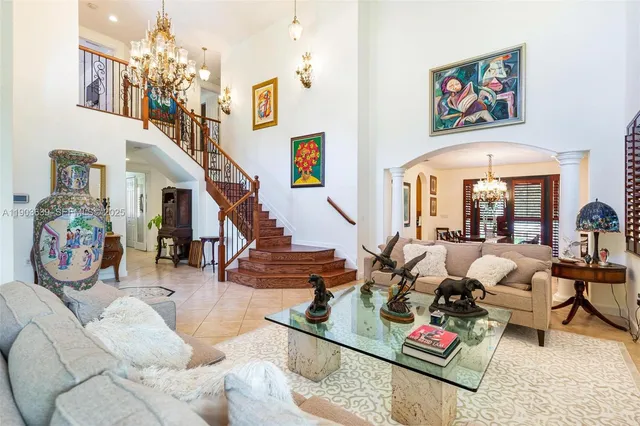 a living room with patio furniture and a chandelier