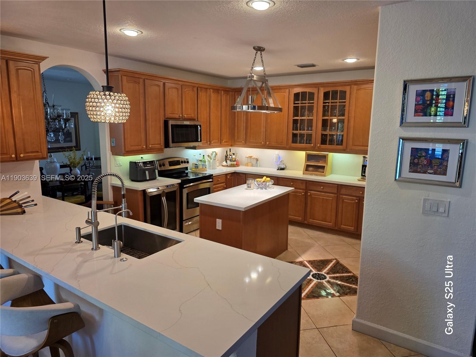 7587 Southwest 189th Street Cutler Bay, FL 33157 - Photo 19 of 66 a kitchen with a sink a stove and chairs